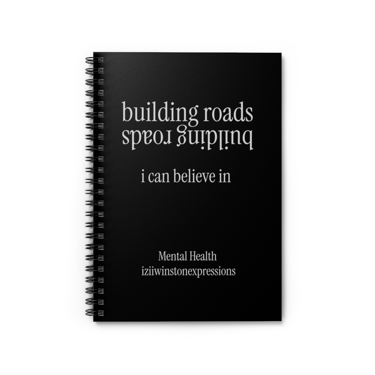 Black spiral notebook with "building roads i can believe in" and "Mental Health iziiwinstonexpressions" printed on the cover.